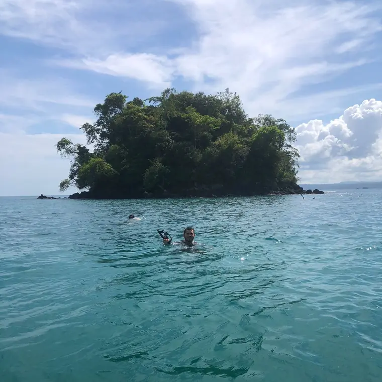 Snorkeling beside a tiny forested island