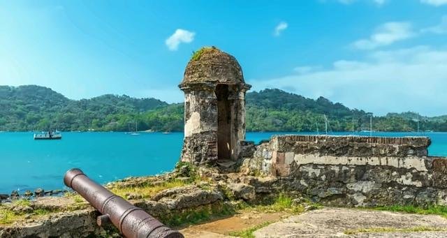 Colonial sentry box and cannon above the turquoise bay of Portobelo, Colón